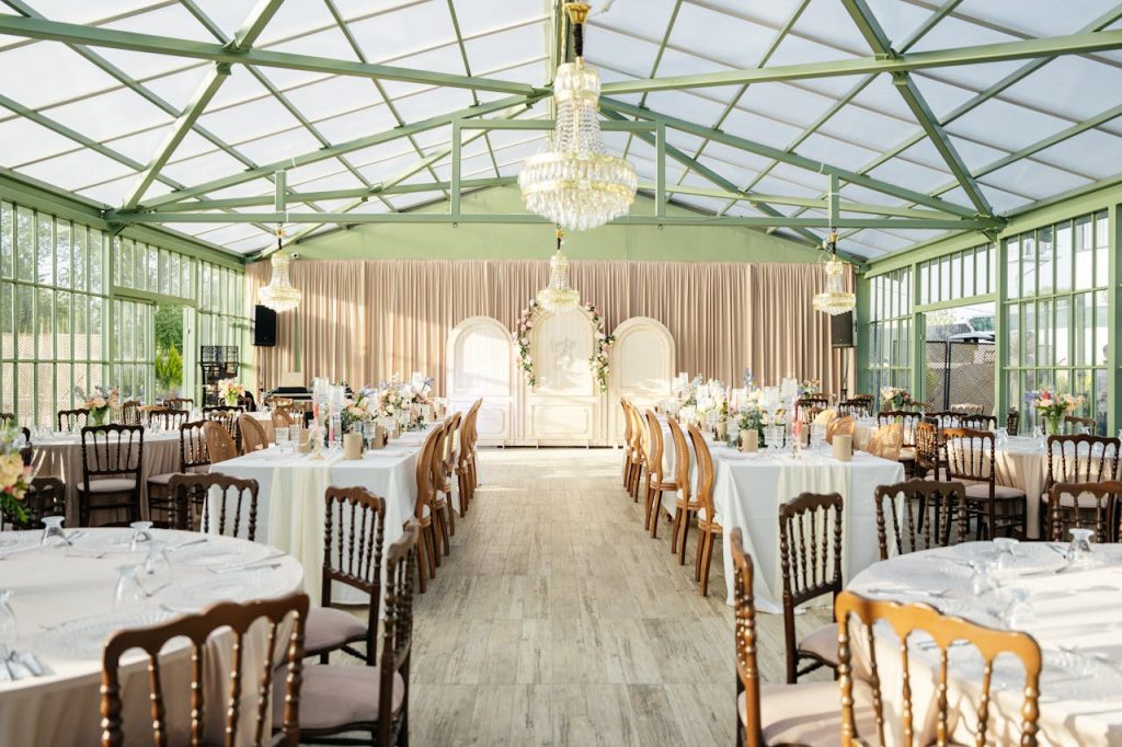 A wedding reception in a large glass greenhouse